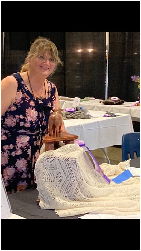 Judge Laura Todd with Margo Siebenbergens Shetland Stars Shawl which was awarded the Black Sheep Cup. Photo: Lucy Kingsley.